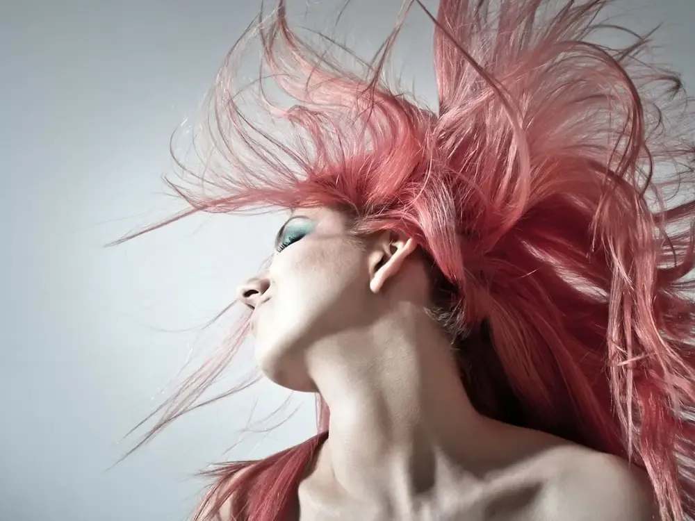 Retrato de moda con el pelo en movimiento sobre fondo claro