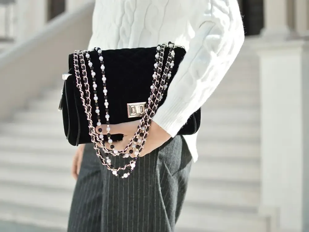 Bolso acolchado con cadena colgado del hombro de una modelo